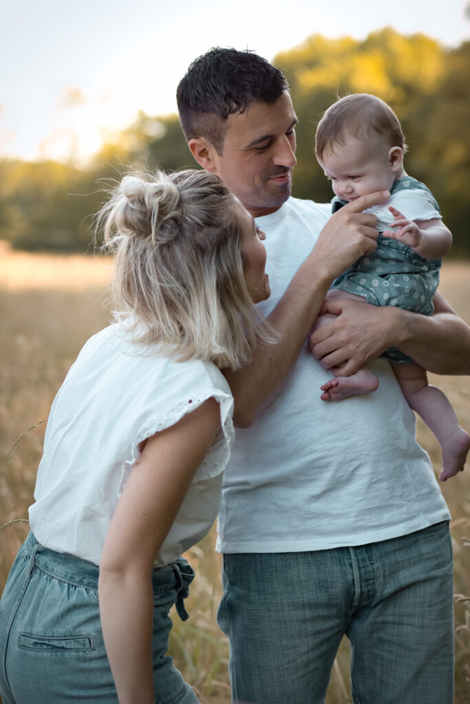 Ein Baby auf Papas Arm lacht mit Mama